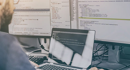 Man at a computer protecting a business from a potential data breach.