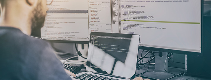 Man at a computer protecting a business from a potential data breach.